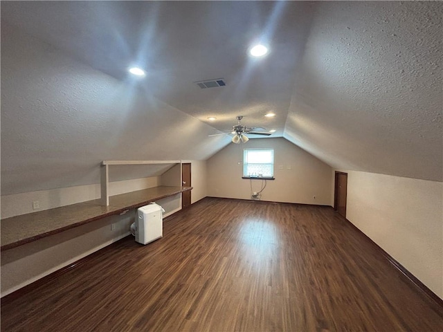 bonus room with vaulted ceiling, dark hardwood / wood-style floors, and a textured ceiling