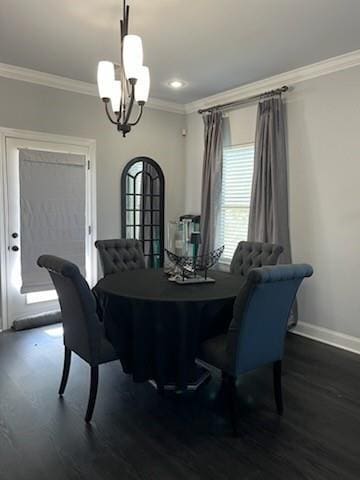 dining area with an inviting chandelier, dark wood-type flooring, and ornamental molding