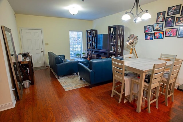 dining room with dark wood-type flooring and a chandelier