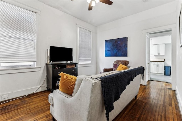 living room featuring dark wood-type flooring and ceiling fan