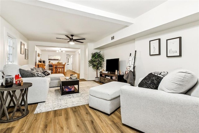 living room with wood-type flooring and ceiling fan