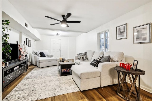 living room with dark wood-type flooring and ceiling fan