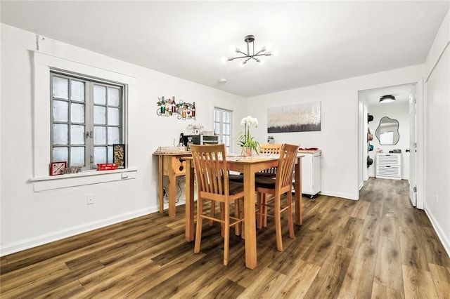 dining space with a notable chandelier, hardwood / wood-style flooring, and a wealth of natural light