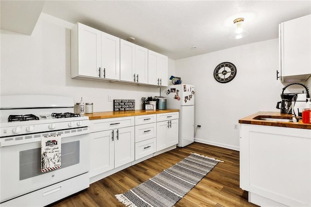 kitchen featuring wood counters, sink, white appliances, and white cabinetry