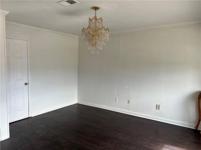 spare room featuring crown molding, dark wood-type flooring, and a chandelier