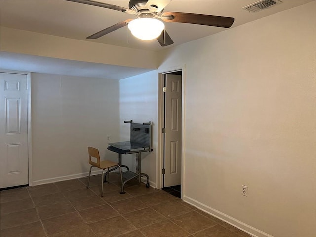 interior space with ceiling fan and dark tile patterned floors