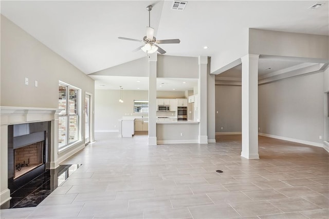 unfurnished living room with ornate columns, ceiling fan, high vaulted ceiling, and a fireplace