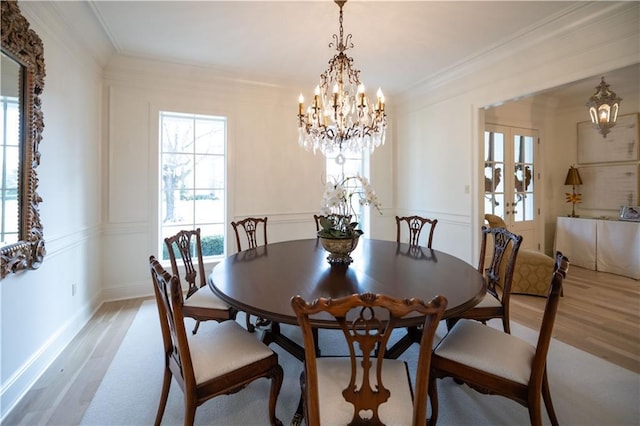 dining area featuring an inviting chandelier, crown molding, and light hardwood / wood-style floors