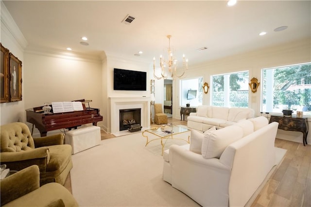 living room with a notable chandelier, light hardwood / wood-style flooring, and ornamental molding