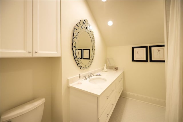 bathroom featuring lofted ceiling, vanity, and toilet