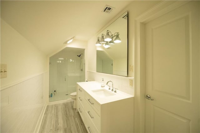 bathroom featuring a shower with door, vanity, hardwood / wood-style flooring, and toilet