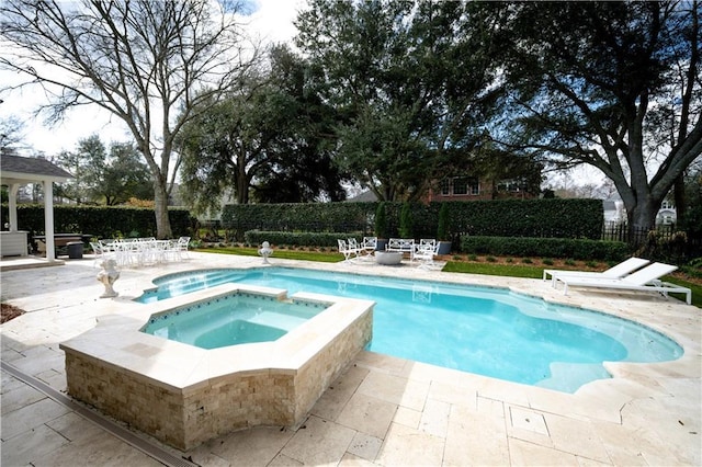 view of pool with an in ground hot tub and a patio