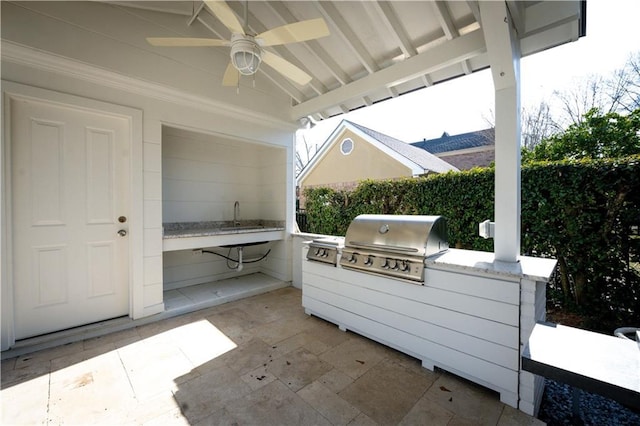 view of patio / terrace with area for grilling, ceiling fan, and an outdoor kitchen