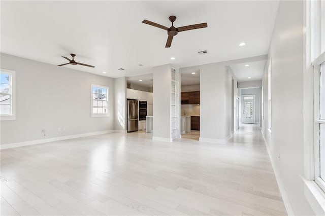 unfurnished living room featuring ceiling fan and light wood-type flooring