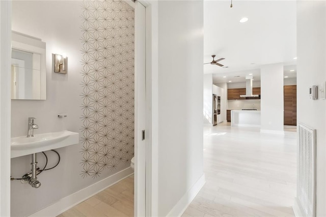 bathroom with hardwood / wood-style flooring, ceiling fan, toilet, and sink