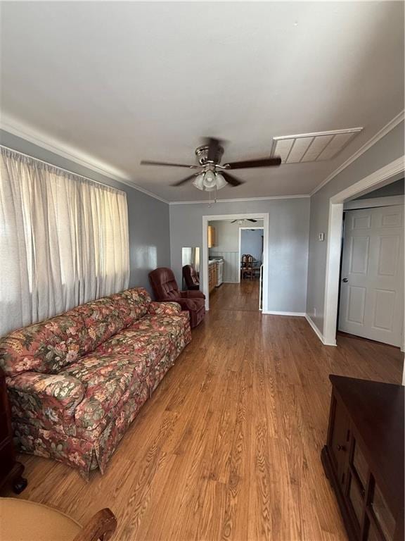 living room with crown molding, light hardwood / wood-style flooring, and ceiling fan