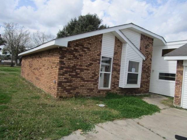 view of side of home with a yard