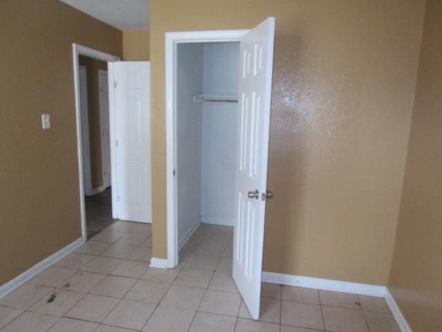 unfurnished bedroom with a closet and light tile patterned flooring