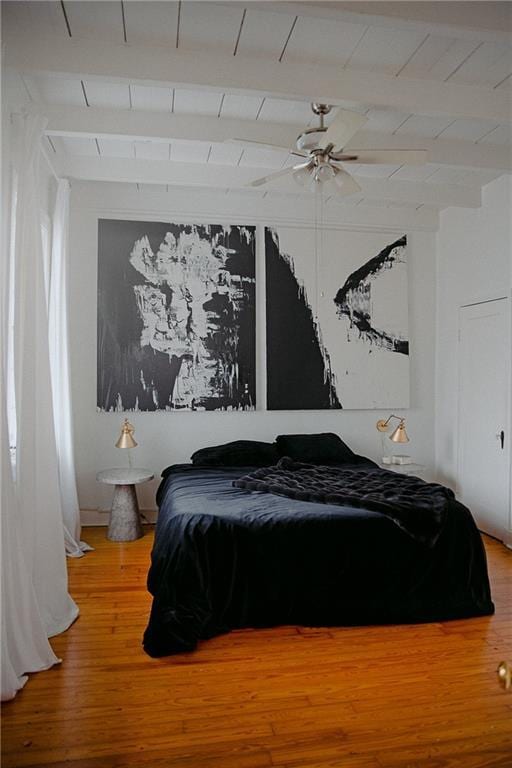 bedroom with hardwood / wood-style floors, beamed ceiling, and ceiling fan