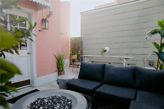 balcony with an outdoor living space with a fire pit and a patio