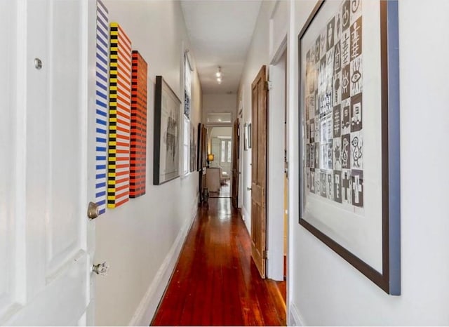 hallway with baseboards and wood finished floors