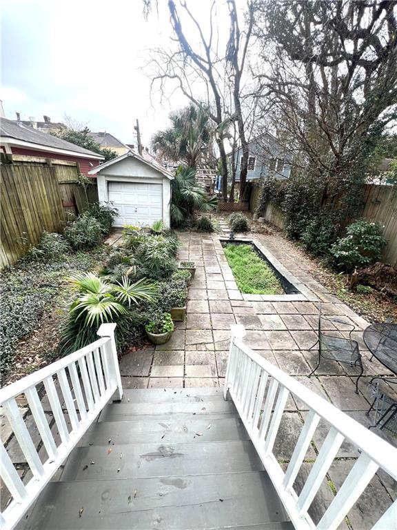 exterior space with an outdoor structure, a fenced backyard, and a detached garage