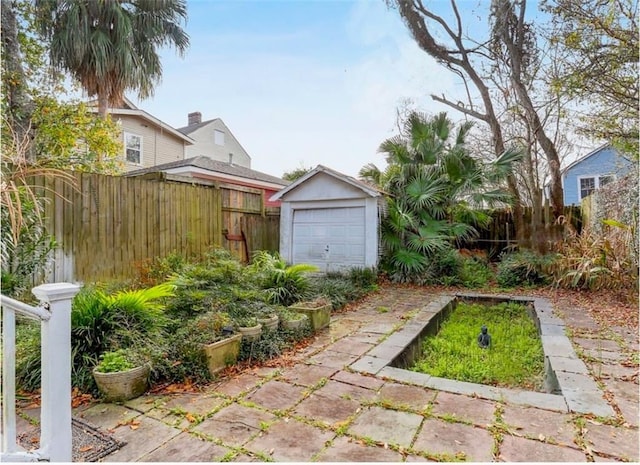 view of yard featuring an outbuilding, fence, and a detached garage