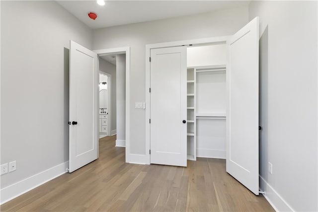 unfurnished bedroom featuring a closet and light hardwood / wood-style flooring