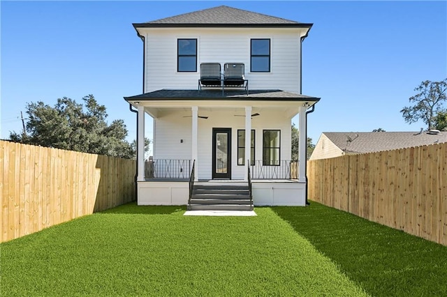 back of property featuring a yard and covered porch