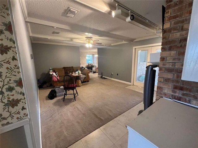 living room with light carpet, ceiling fan, track lighting, and a textured ceiling