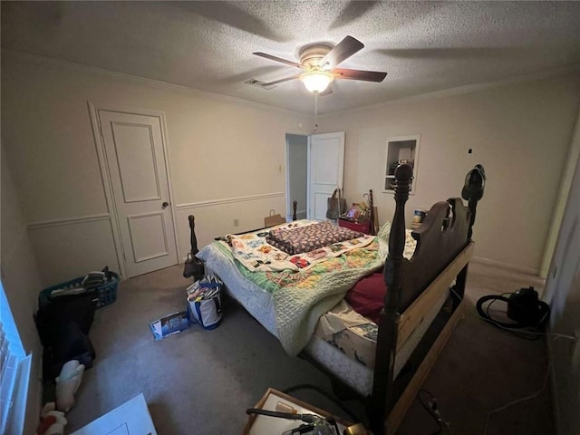 carpeted bedroom featuring ceiling fan, ornamental molding, and a textured ceiling