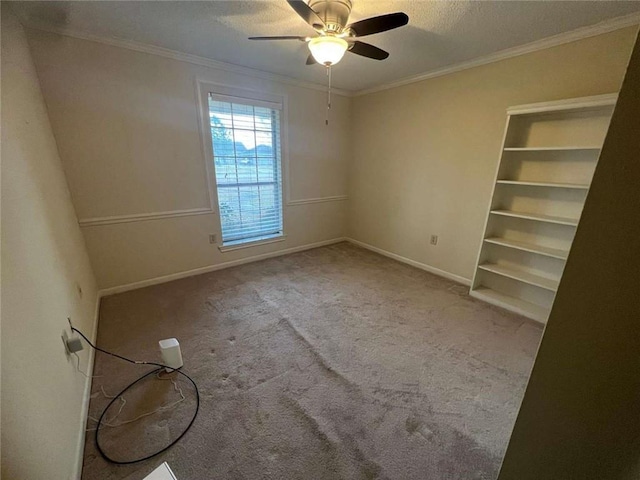 carpeted empty room featuring a textured ceiling, built in features, ornamental molding, and ceiling fan