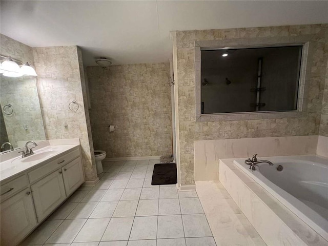 bathroom featuring tile patterned flooring, vanity, a relaxing tiled tub, and toilet