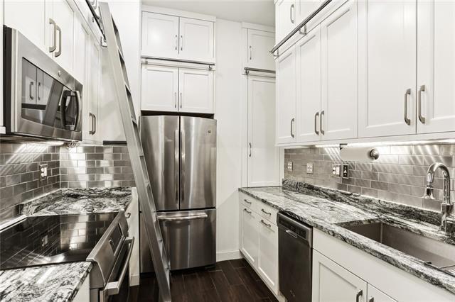 kitchen with white cabinetry, sink, light stone counters, and appliances with stainless steel finishes