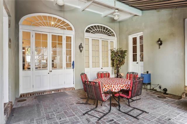 sunroom / solarium featuring beam ceiling, ceiling fan, and french doors