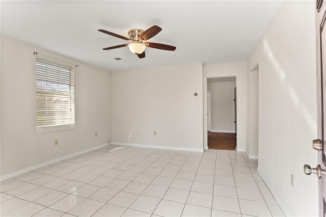 empty room with ceiling fan and light tile patterned floors