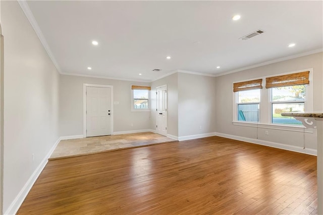 foyer with crown molding and hardwood / wood-style floors