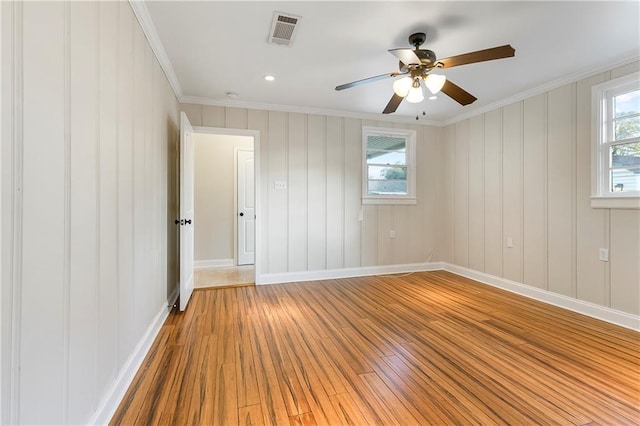 empty room with crown molding, hardwood / wood-style floors, and ceiling fan