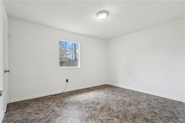 unfurnished room with a textured ceiling