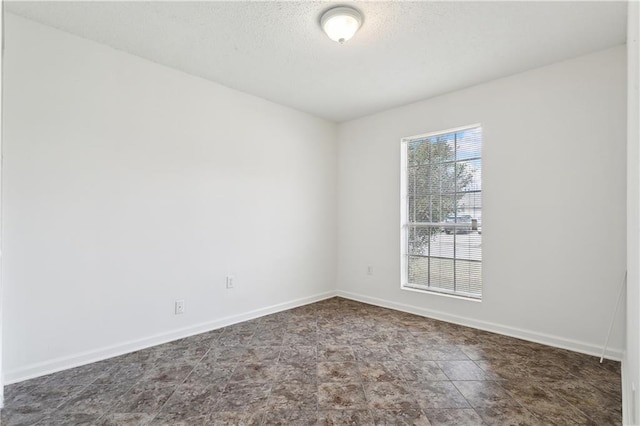 unfurnished room with a textured ceiling