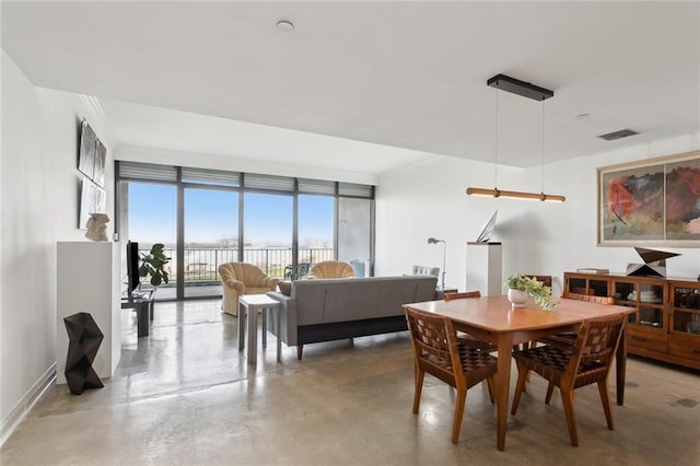 dining space featuring concrete flooring and expansive windows