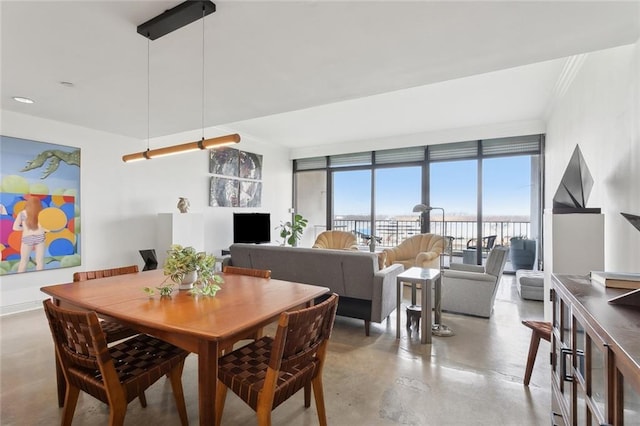 dining area with crown molding and a wall of windows