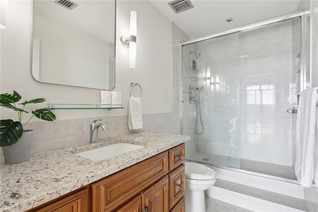 bathroom with vanity, a shower with shower door, and toilet