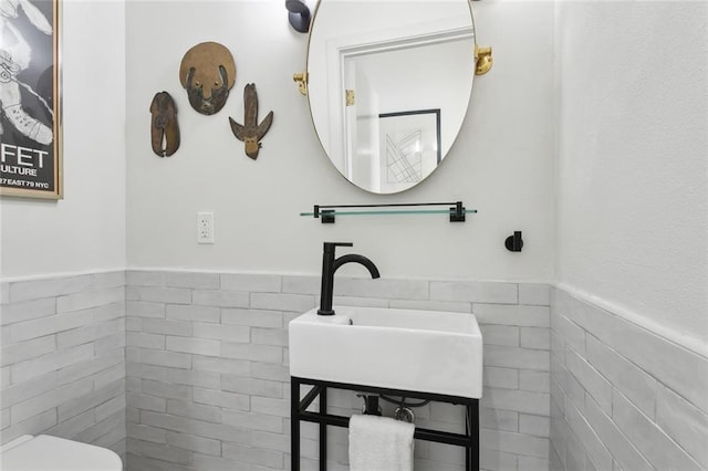 bathroom featuring sink and tile walls