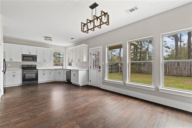 kitchen with sink, appliances with stainless steel finishes, dark hardwood / wood-style floors, white cabinets, and decorative light fixtures