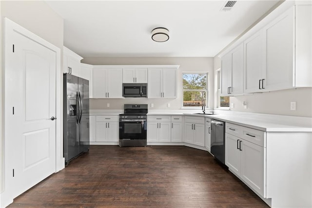 kitchen featuring stainless steel appliances, sink, white cabinets, and dark hardwood / wood-style floors