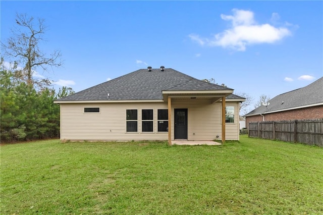 rear view of property with a yard and a patio