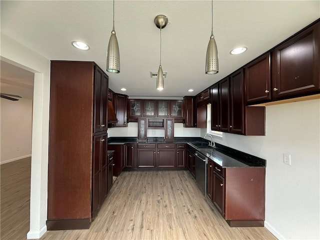 kitchen featuring hanging light fixtures, dishwasher, sink, and light hardwood / wood-style flooring