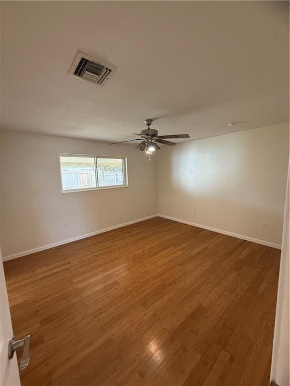 spare room with hardwood / wood-style floors and ceiling fan