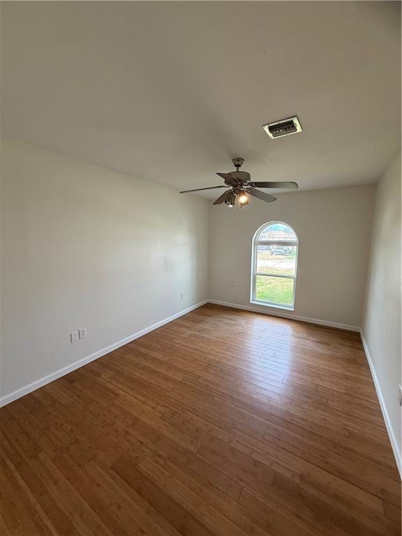 spare room featuring dark wood-type flooring and ceiling fan